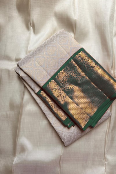 Kanjivaram-Style Cream Banarasi Soft Silk Saree with Wide Gold Zari Border in Green or Red in Surat