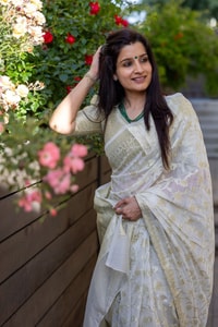 Off-White Saree with Pastel Green Woven Floral Motifs and Soft Silver Zari Accents  in Surat