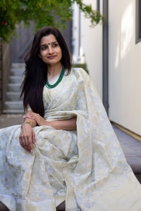 Off-White Saree with Pastel Green Woven Floral Motifs and Soft Silver Zari Accents  in Surat