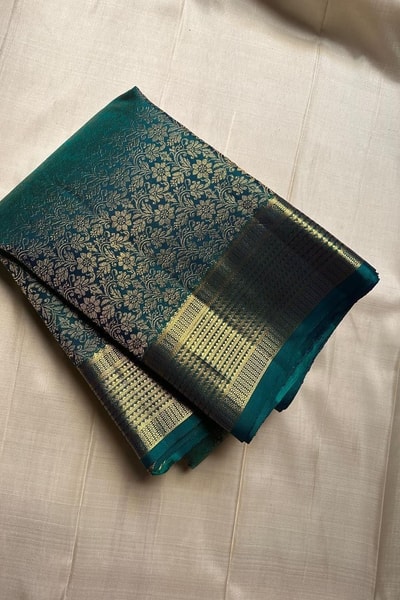 Peacock Teal Banarasi Soft Silk Saree with All-Over Zari Motifs and Gold Temple Border in Surat